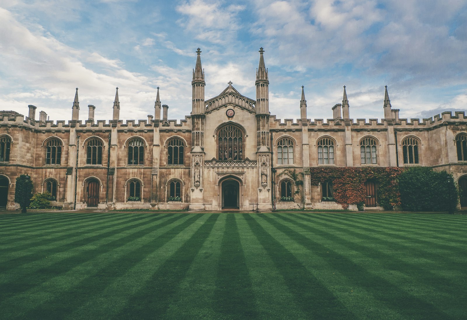 A historic collegiate quad with twin towers and a striped lawn