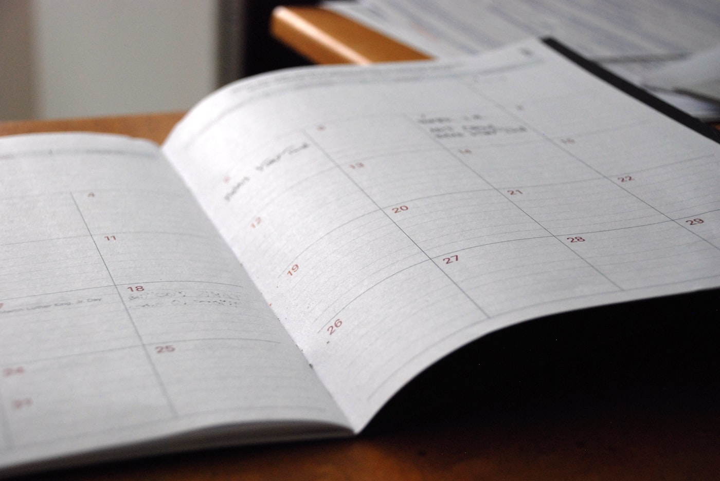 An open monthly planner on a wooden desk