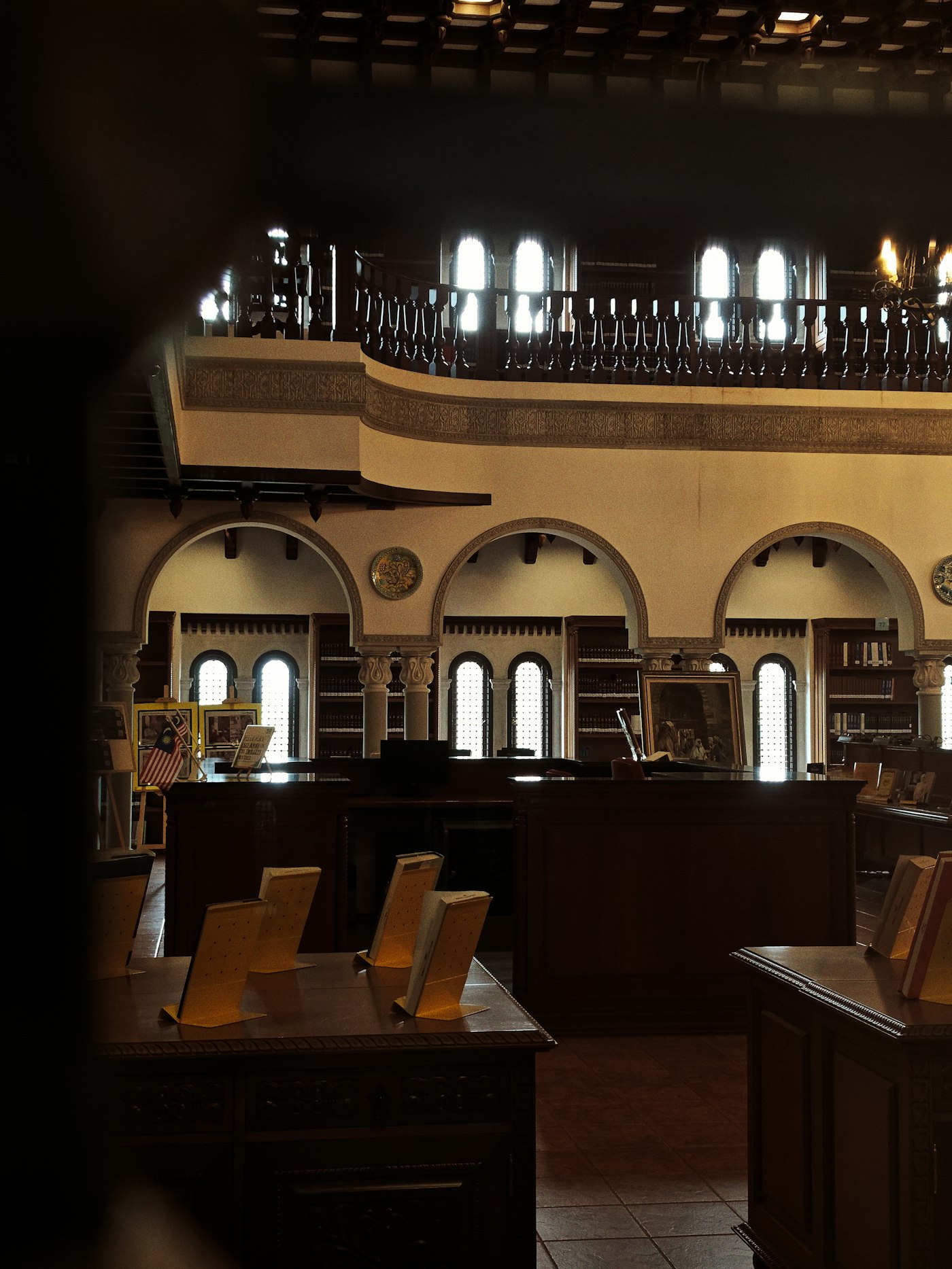 A grand library reading room with arched galleries and study desks